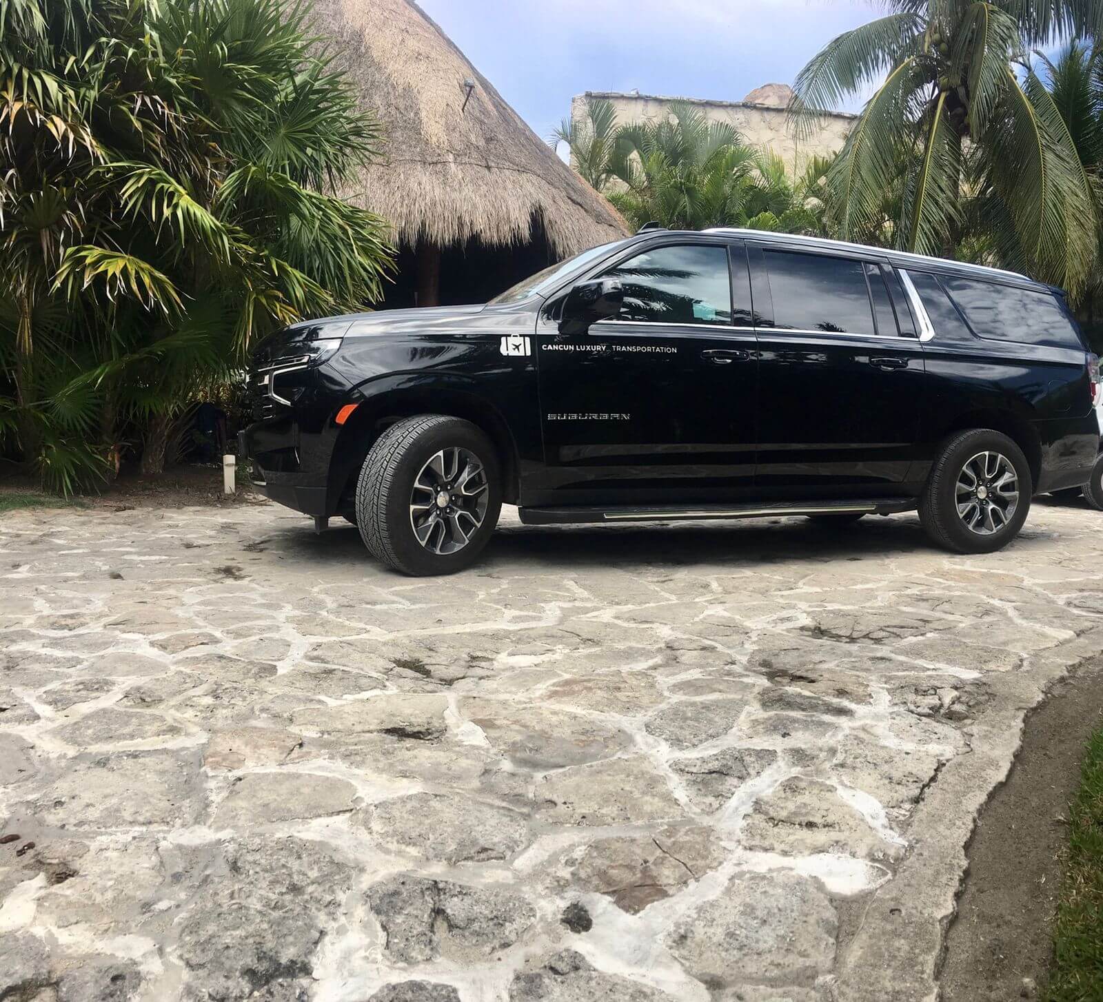 Luxury black Suburban 2021 parked in front of a palapa